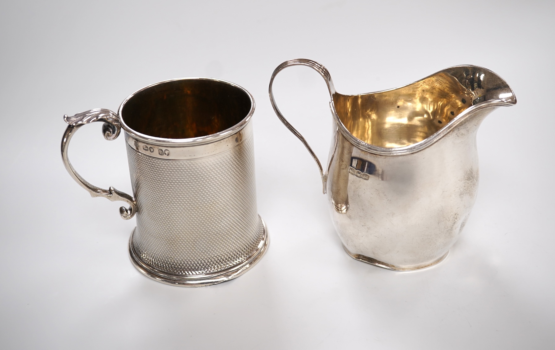 A Victorian engine turned silver christening mug by John Samuel Hunt (Hunt & Roskell), London, 1863, with later engraved inscription to the base, height 89mm, together with a George VI silver cream jug, London, 1947, 12o